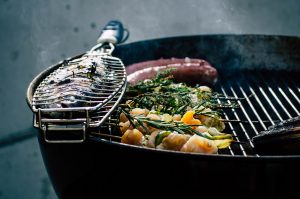 A BBQ over wood with fish and assorted kebabs.